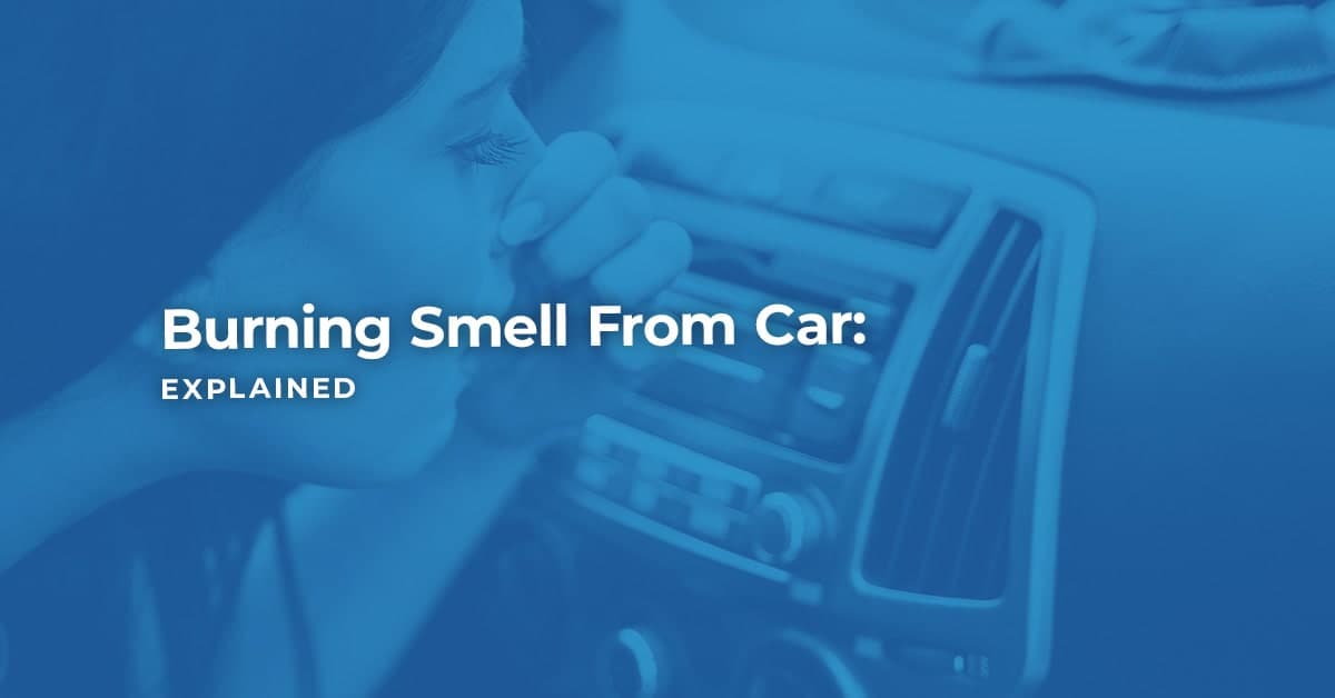 female driver holding her nose and checking car air con system for burning smell